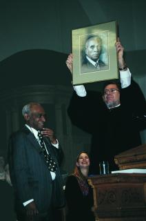 W.H.G. Carter's portrait is held aloft by the Rev. Morris Hudgins as Leslie Edwards (left) and the Rev. Sharon Dittmar look on.