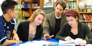 Don Schawang (in blazer) teaches owl to students in his senior year ethics class at Bishop Seabury Academy.