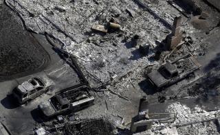 Charred vehicles are seen next to a wildfire-ravaged home in an aerial view Saturday, Oct. 14, 2017, in Santa Rosa, Calif.