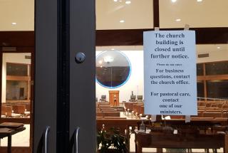 Photo of a sign on the door of the UU Church in Baton Rouge, La., saying "this church building is closed until further notice."