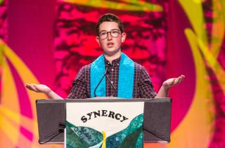 Emerson Finkle leads a responsive reading during the Synergy Bridging Worship honoring the transition from youth to young adulthood at GA 2019.