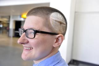 Person with flaming chalice shaved into their hair