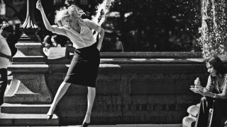 Greta Gerwig dancing in front of fountain.