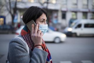 Young Woman With Face Mask Talking On The Phone. stock photo
