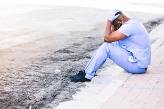 Distraught nurse takes break during COVID shift stock photo
