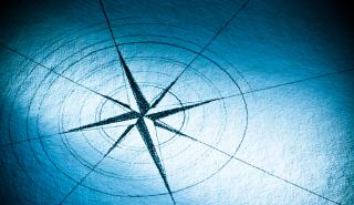 Hand-drawn compass rose on blue paper - Stock image
