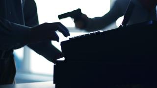 silhouette of cash register and armed robber