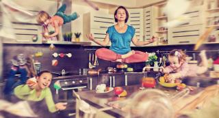 photo illustration of meditating woman in kitchen surrounded by children and swirling objects in mid-air