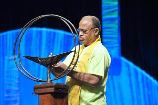 The Rev. Mel Hoover lit the chalice at the start of a General Assembly worship service Thursday, June 20. On Saturday, June 22, he received the UUA's Distinguished Service Award.