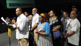 Members of the UU people of color organization DRUUMM introduced a responsive resolution at the end of the final plenary session June 23.