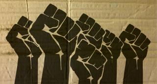Stock photo of Black Lives Matter fists on a cardboard background