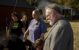 The Rev. Ron Robinson, his wife Dr. Bonnie Ashing, and other A Third Place supporters pray over a tree they just planted outside the church they are buying to house their community ministry in Turley, Oklahoma.