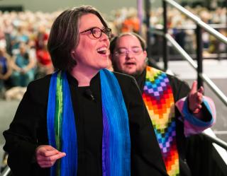 UUA President Susan Frederick- Gray and the Rev. Sunshine Wolfe (who wears a trans pride flag on their arm, as many members of truust did at GA) take the stage during the Sunday morning worship service June 23, 2019.
