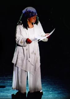 Photo of Poet, playwright, educator, and activist Sonia Sanchez, reading her poetry on stage. 