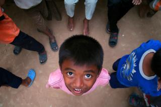 A young Cambodian orphan smiles while waiting for English class to begin