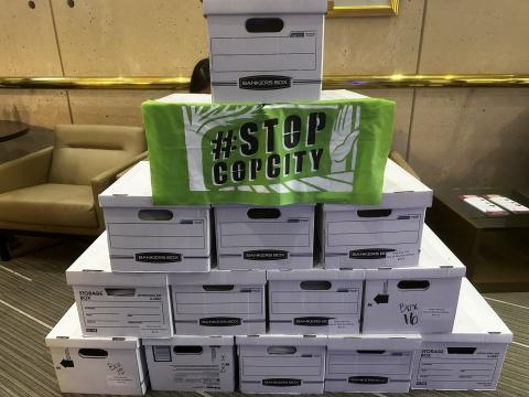 A stack of boxes with petitions against a proposed 'Cop City' sit in an office
